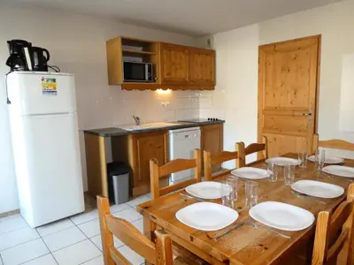 a kitchen with a wooden table with chairs and a white refrigerator at Résidence Le Grand Panorama - Grand Panorama 514 MAE-5204 in Saint-Gervais-les-Bains