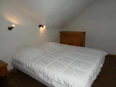 a bedroom with a white bed and a wooden cabinet at Résidence Le Grand Panorama - Grand Panorama 514 MAE-5204 in Saint-Gervais-les-Bains