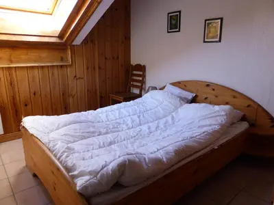 a bedroom with a wooden bed with white sheets at Résidence Les Jardins Alpins - Jardins Alpins B29 MAE-5209 in Saint-Gervais-les-Bains