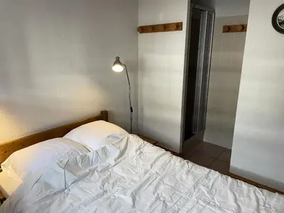 an unmade bed in a room with a lamp at Résidence Les Jardins Alpins - Jardins Alpins B03 MAE-5231 in Saint-Gervais-les-Bains