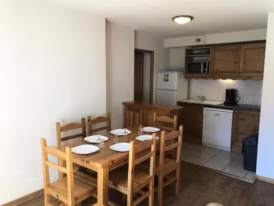 a kitchen with a wooden table with chairs and a kitchen with at Résidence Le Grand Panorama - Grand Panorama 107 MAE-5232 in Saint-Gervais-les-Bains