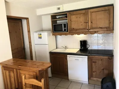 a kitchen with wooden cabinets and a white refrigerator at Résidence Le Grand Panorama - Grand Panorama 107 MAE-5232 in Saint-Gervais-les-Bains