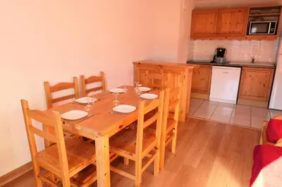 a wooden dining room table with chairs and a kitchen at Résidence Le Grand Panorama - Grand Panorama 409 MAE-5252 in Saint-Gervais-les-Bains
