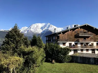 a building with a snow covered mountain in the background at Résidence La Gelinotte - Gelinotte 04 MAE-5260 in Saint-Gervais-les-Bains