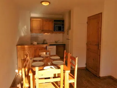 a kitchen with a wooden table with chairs and a tableasteryasteryasteryasteryastery at Résidence Le Grand Panorama - Grand Panorama 211 MAE-5265 in Saint-Gervais-les-Bains