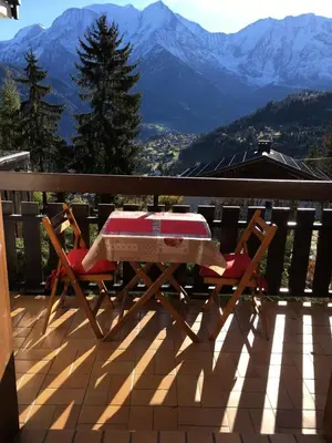 a table and chairs on a deck with a view of mountains at Résidence Les Aiguilles - Bat Vorassay - Vorassay C32 MAE-5293 in Saint-Gervais-les-Bains