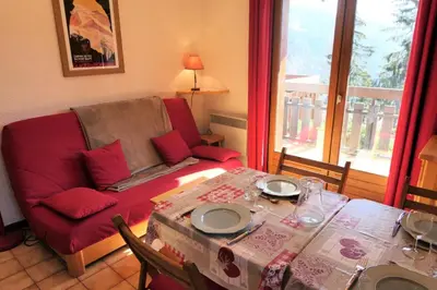 a living room with a table and a red couch at Résidence Les Aiguilles - Bat Vorassay - Vorassay C32 MAE-5293 in Saint-Gervais-les-Bains