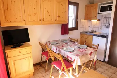 a kitchen with a table with chairs and a television at Résidence Les Aiguilles - Bat Vorassay - Vorassay C32 MAE-5293 in Saint-Gervais-les-Bains