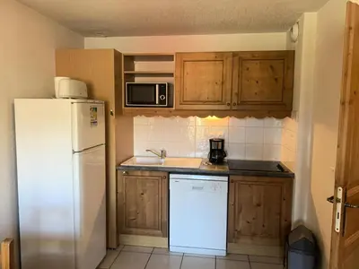 a kitchen with a white refrigerator and wooden cabinets at Résidence Le Grand Panorama - Grand Panorama 202 MAE-5294 in Saint-Gervais-les-Bains