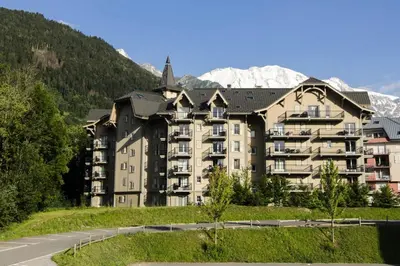 a large apartment building with mountains in the background at Résidence Le Grand Panorama - Grand Panorama 102 MAE-5295 in Saint-Gervais-les-Bains
