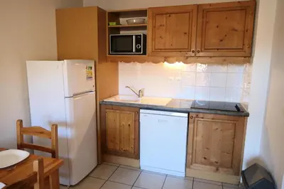 a kitchen with a white refrigerator and a sink at Résidence Le Grand Panorama - Grand Panorama 102 MAE-5295 in Saint-Gervais-les-Bains