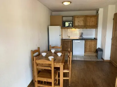 a kitchen with a table and chairs and a refrigerator at Résidence Le Grand Panorama - Grand Panorama 402 MAE-5297 in Saint-Gervais-les-Bains