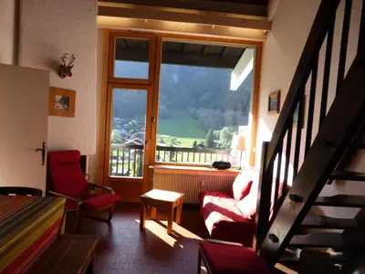 a living room with a staircase and a large window at Résidence Bionnassay - Bionnassay B181 MAE-5332 in Les Contamines-Montjoie