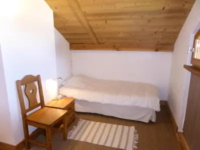 a small bedroom with a bed and a chair at Chalet Champelet - Chalet Champelet MAE-5333 in Les Contamines-Montjoie