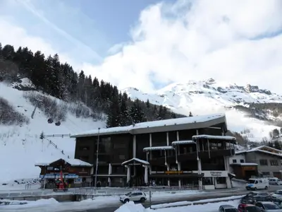 a building with snow on it in front of a mountain at Résidence Schuss - Schuss B230 MAE-5335 in Les Contamines-Montjoie