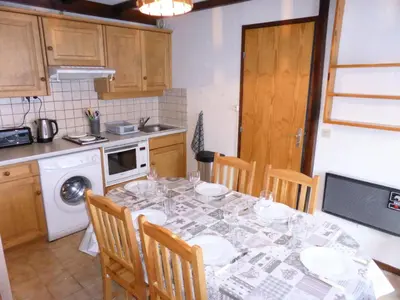 a kitchen with a table and chairs and a kitchen with a stove at Résidence Schuss - Schuss B230 MAE-5335 in Les Contamines-Montjoie
