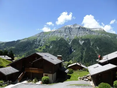 a mountain in the distance with houses in the foreground at Résidence Floralie - Domaine Des Lapons 2 - Lapons 2 Floralie 6 MAE-5337 in Les Contamines-Montjoie