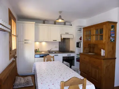a kitchen with white cabinets and a table in it at Résidence Cressoua - Cressoua A11 MAE-5338 in Les Contamines-Montjoie