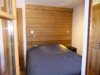 a bed in a room with a wooden wall at Résidence Cressoua - Cressoua A11 MAE-5338 in Les Contamines-Montjoie