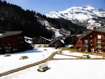 a town with snow covered buildings and a mountain at Résidence Pierres Blanches - Pierres Blanches H579 MAE-5342 in Les Contamines-Montjoie