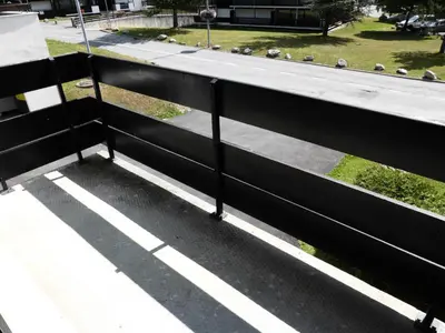 a black fence on a sidewalk with a street at Résidence Le Brulaz - Brulaz F1E MAE-5347 in Les Contamines-Montjoie