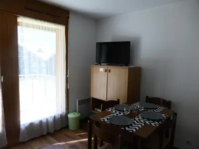 a dining room with a table with chairs and a television at Résidence L'enclave - Enclave I638 MAE-5354 in Les Contamines-Montjoie