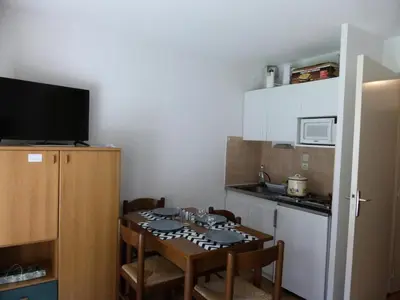 a small kitchen with a table with chairs and a microwave at Résidence L'enclave - Enclave I638 MAE-5354 in Les Contamines-Montjoie