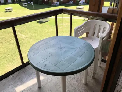 a glass table and a white chair on a balcony at Résidence L'enclave - Enclave I638 MAE-5354 in Les Contamines-Montjoie