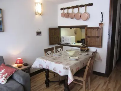 a dining room with a table and a kitchen at Résidence Bionnassay - Bionnassay B159 MAE-5357 in Les Contamines-Montjoie