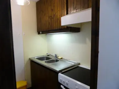a small kitchen with a sink and wooden cabinets at Résidence Bionnassay - Bionnassay B159 MAE-5357 in Les Contamines-Montjoie