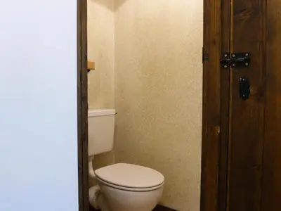 a bathroom with a white toilet and a wooden door at Résidence Bionnassay - Bionnassay B159 MAE-5357 in Les Contamines-Montjoie