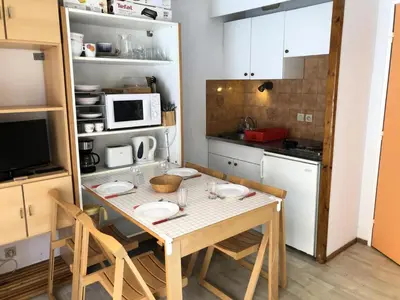 a small kitchen with a table with chairs and a microwave at Résidence Borgia - Borgia A3 MAE-5367 in Les Contamines-Montjoie