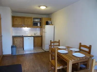 a kitchen with a wooden table and a white refrigerator at Résidence Le Grand Panorama - Grand Panorama 115 MAE-5286 in Saint-Gervais-les-Bains