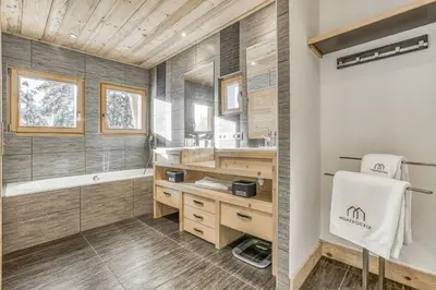 a bathroom with a tub and a sink and a bath tub at Chalet Nepal in Megève