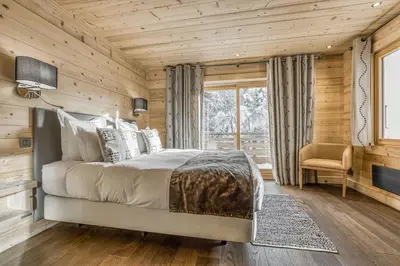 a bedroom with a bed and a window at Chalet Nepal in Megève