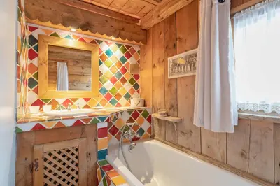 a bathroom with a tub and a mirror at Chalet Ontario in Demi-Quartier