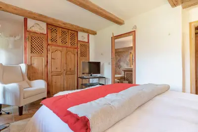 a bedroom with a bed and a chair and a television at Chalet Ontario in Demi-Quartier