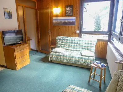 a living room with a couch and a television at Studio L'Aiguille du Midi-9 by Interhome in Chamonix-Mont-Blanc