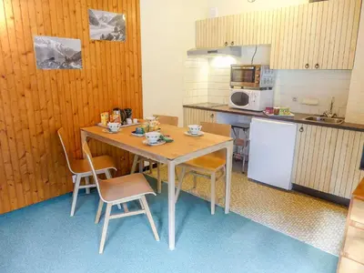 a kitchen with a table and chairs and a refrigerator at Studio L'Aiguille du Midi-9 by Interhome in Chamonix-Mont-Blanc