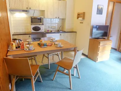 a small kitchen with a wooden table and chairs at Studio L'Aiguille du Midi-9 by Interhome in Chamonix-Mont-Blanc