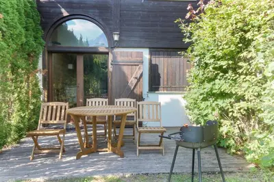 a patio with a table and chairs and a grill at House Berenice - Chamonix les Praz in Chamonix-Mont-Blanc