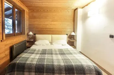 a bedroom with a bed in a wooden room at House Berenice - Chamonix les Praz in Chamonix-Mont-Blanc