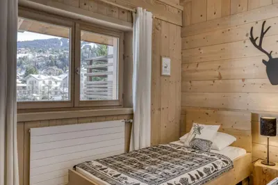 a bedroom with a bed and a window at Appartement Amour in Megève