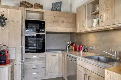 a kitchen with wooden cabinets and a sink at Appartement Amour in Megève