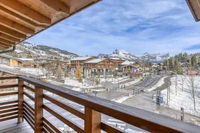 a view from the balcony of a resort with snow covered mountains at Appartement Amour in Megève