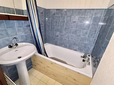 a blue tiled bathroom with a sink and a bath tub at Appartement cosy 2 pièces, 6 couchages, balcon, garage et casier à skis, Demi-Quartier - FR-1-597-9 in Demi-Quartier