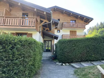a house with a balcony and some bushes at Appartement cosy 2 pièces, 6 couchages, balcon, garage et casier à skis, Demi-Quartier - FR-1-597-9 in Demi-Quartier