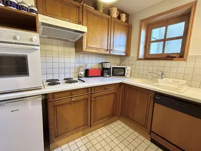 a kitchen with wooden cabinets and white appliances at Duplex à Megève, 6 Couchages, Proche Centre et Pistes - FR-1-597-4 in Megève