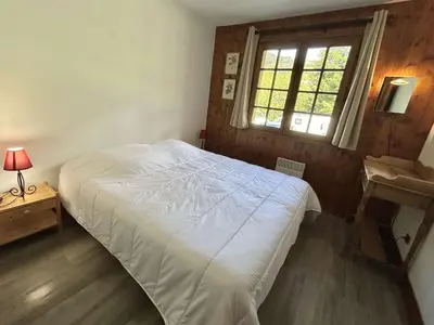 a bedroom with a white bed and a window at Duplex 4 pièces, 8 couchages, jardin, parking, près des pistes - FR-1-597-3 in Megève