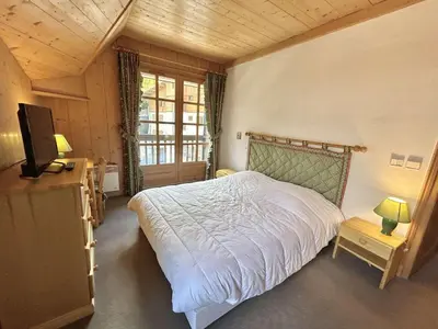 a bedroom with a bed and a television in it at Confortable Duplex 3 Pièces, 6 Couchages, Proche Centre et Télécabine, Balcon Sud, Megève - FR-1-597-8 in Megève